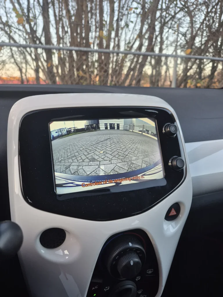 Scherm in auto toont beeld van achteruitrijcamera.