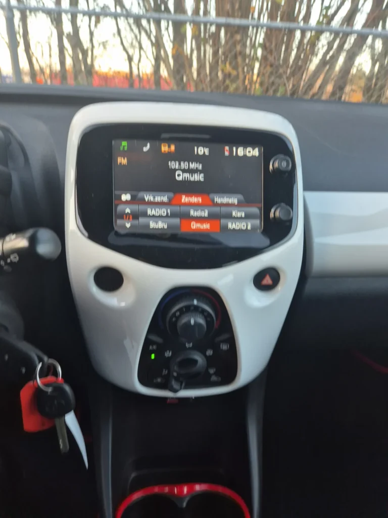 Dashboard met autoradio en airconditioning knoppen.