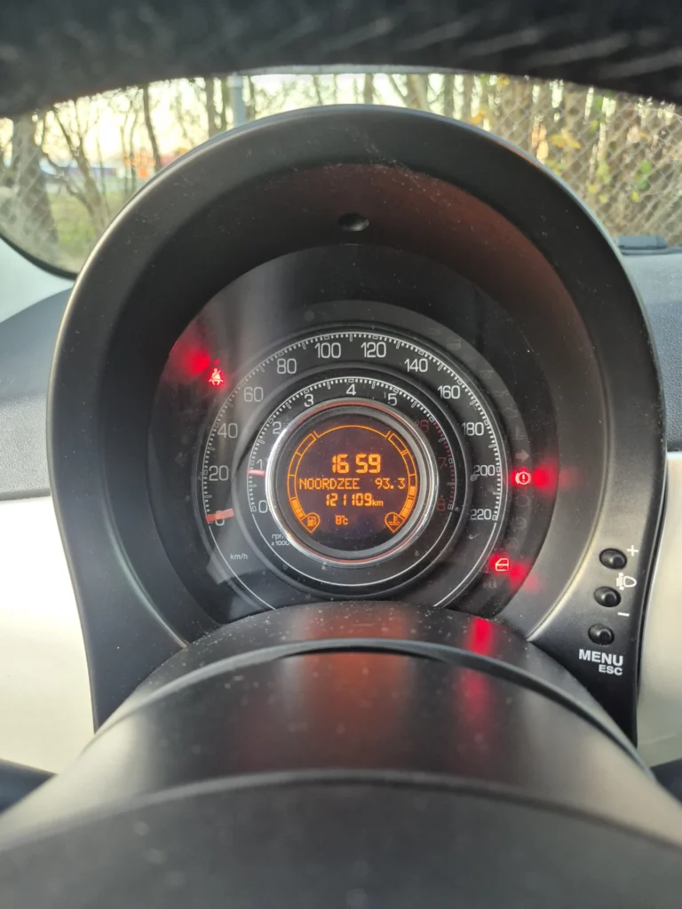 Dashboard met snelheidsmeter en waarschuwingslampjes