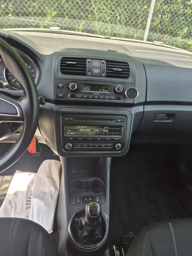 Dashboard en middenconsole van een auto met radio en versnellingspook.