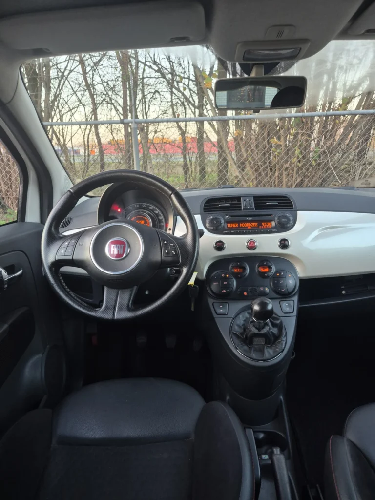 Dashboard en stuur van een auto met zwarte bekleding.