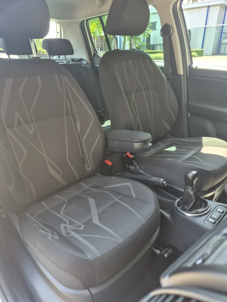 Zwarte autostoelen en dashboard van een auto.