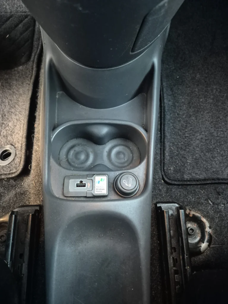 Middenconsole van een auto met bekerhouders en aansluitingen