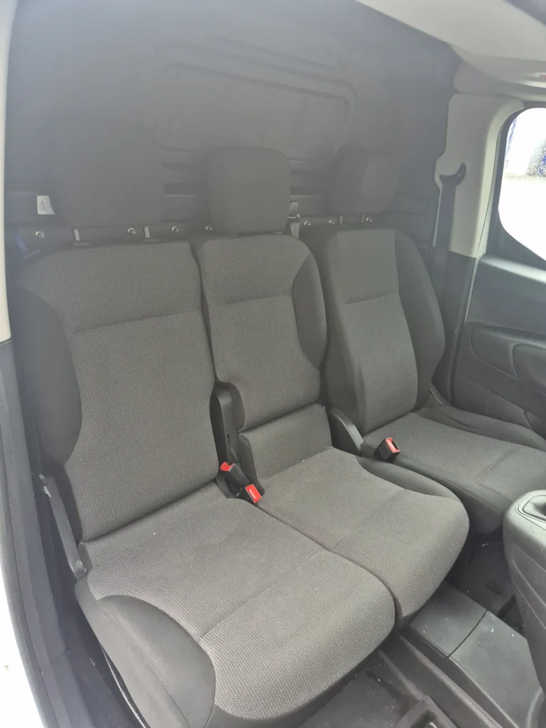Twee grijze autostoelen in een bestelwagen