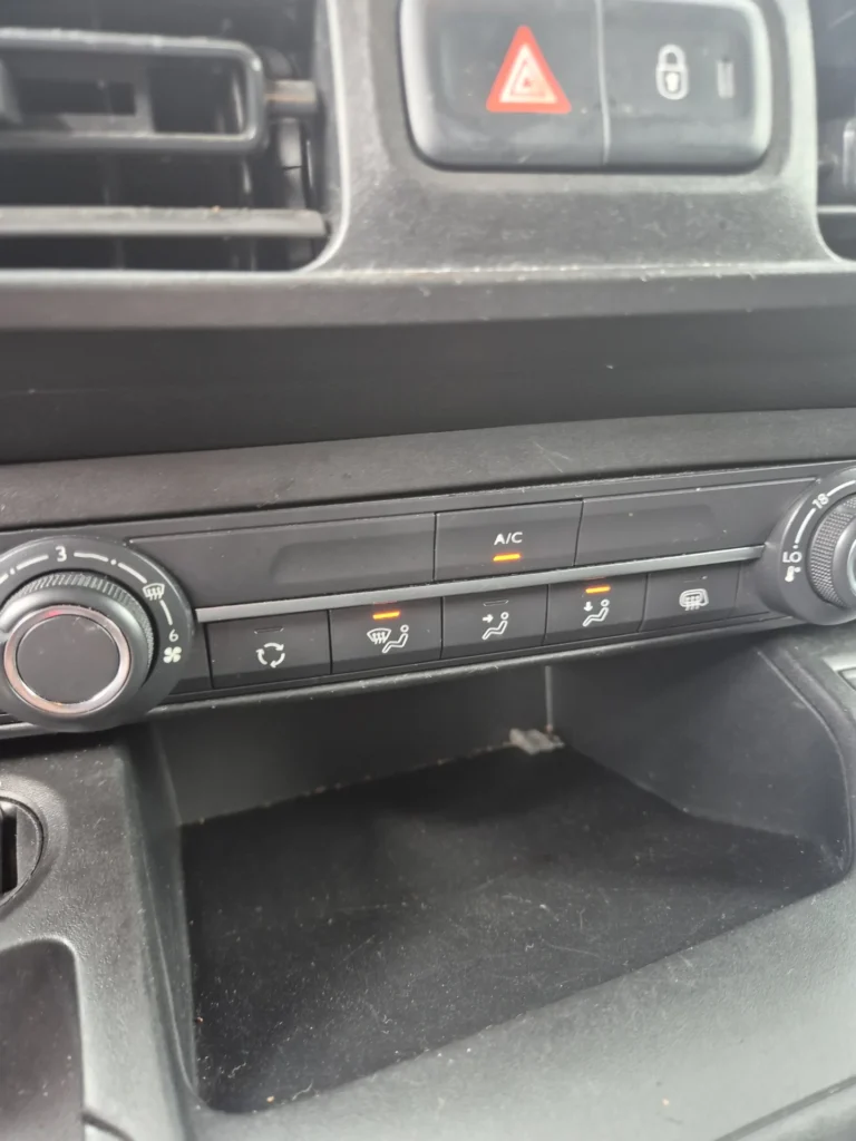 Knoppen voor klimaatregeling op een autodashboard.