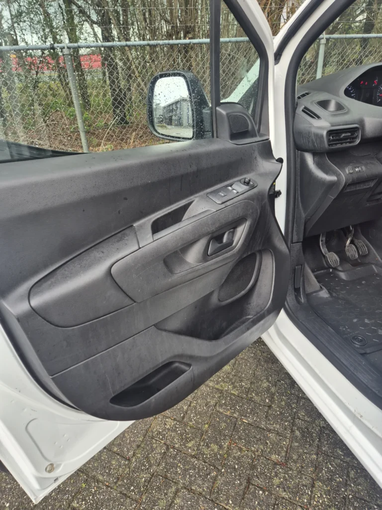 Open autodeur met zicht op interieur en zijspiegel.
