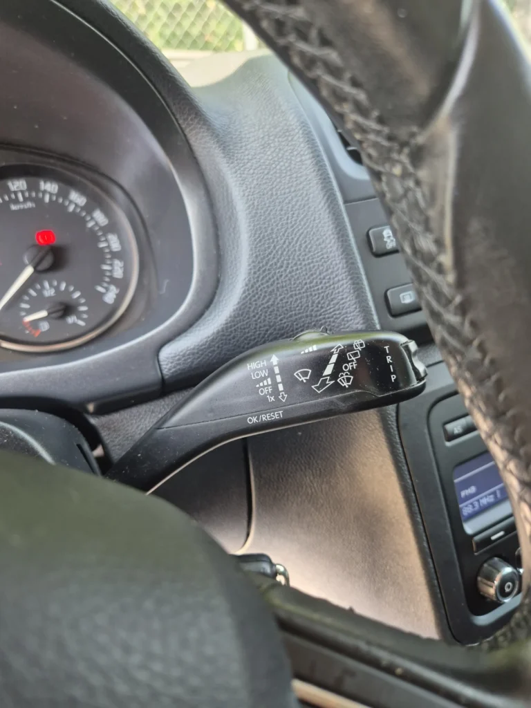 Stuurkolom met hendel en snelheidsmeter in een auto